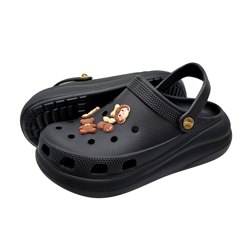 Black EVA clogs with decorative charms, ventilation holes, and adjustable heel strap