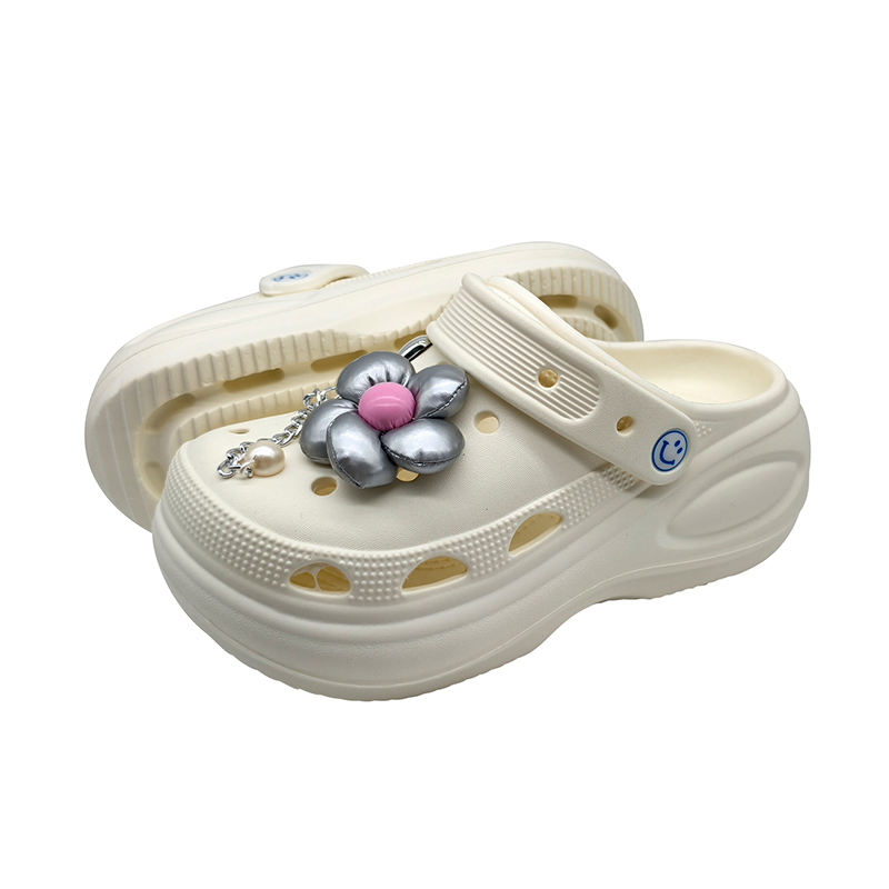 Ivory women's thick-sole EVA clogs with flower charm, ventilation holes, and heel strap