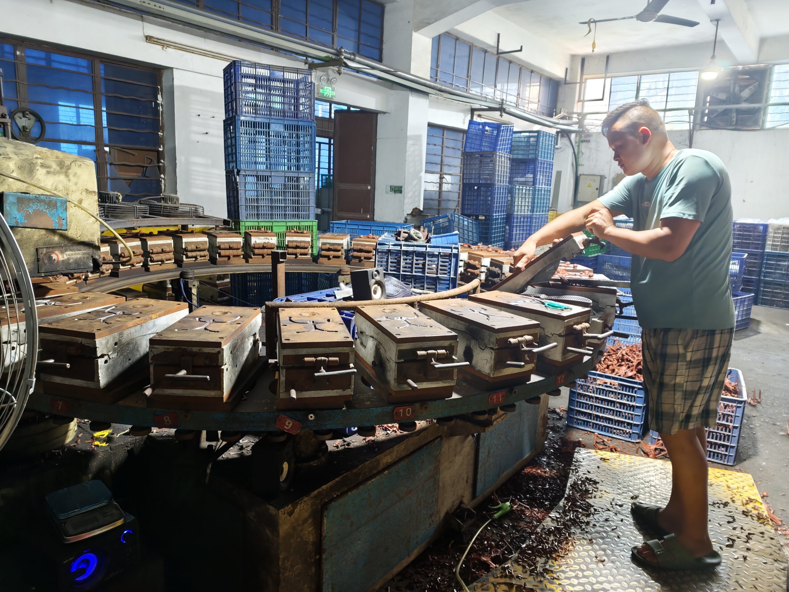 Worker operating footwear molding equipment in a production workshop.